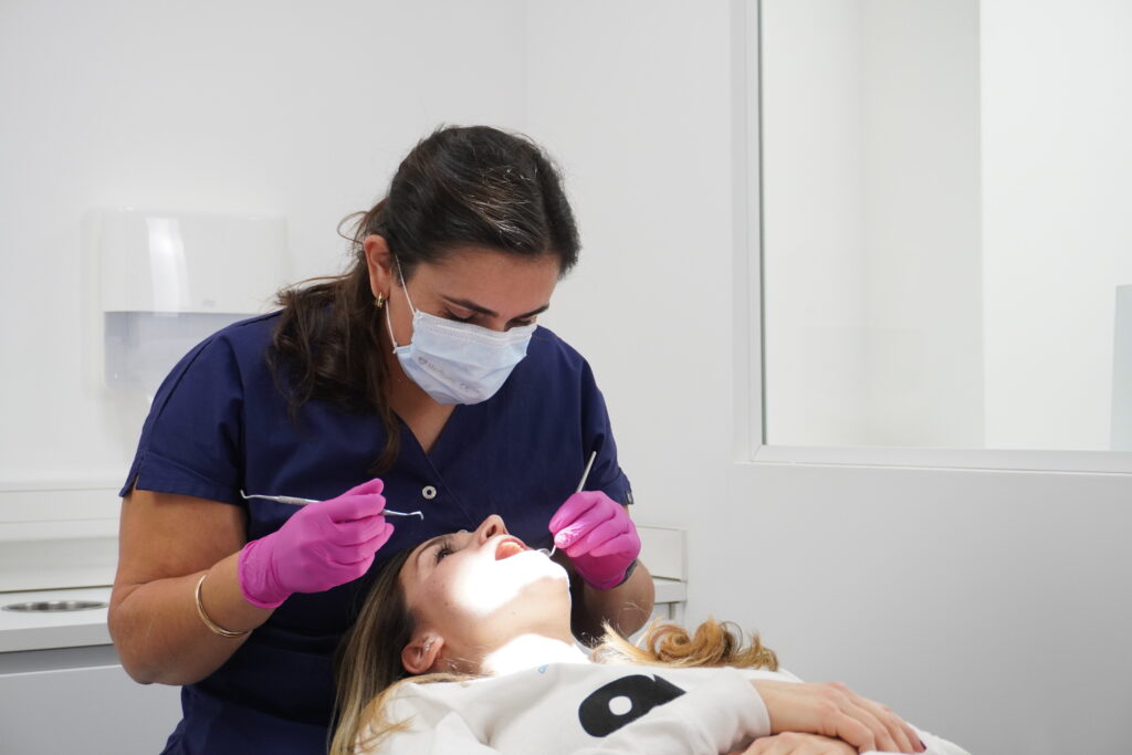 Orthodontiste du cabinet examinant une jeune patiente